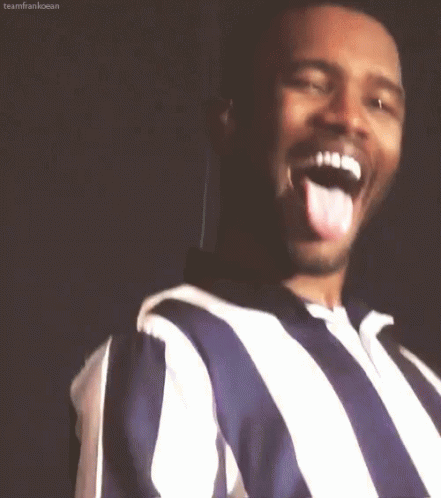 A Man Wearing A Striped Shirt Is Sticking His Tongue Out . GIF