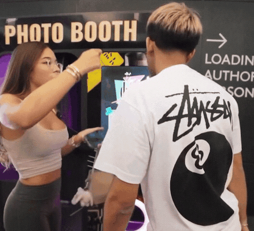 A Man Wearing A Stussy Shirt Stands Next To A Woman GIF