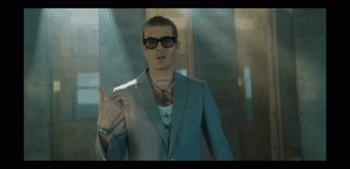 A Man Wearing A Suit And Sunglasses Is Giving A Thumbs Up Sign GIF