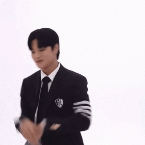 A Man Wearing A Suit And Tie Is Dancing . GIF