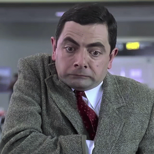 A Man Wearing A Suit And Tie Is Looking At The Camera GIF
