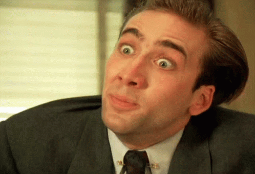 A Man Wearing A Suit And Tie Is Making A Funny Face GIF