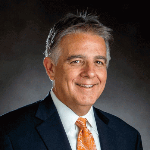 A Man Wearing A Suit And Tie Is Smiling For The Camera GIF