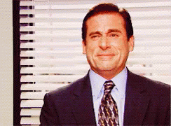 A Man Wearing A Suit And Tie Is Smiling In Front Of A Window GIF