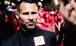 A Man Wearing A Suit And Tie Is Talking Into A Microphone With The Number 11 On It GIF