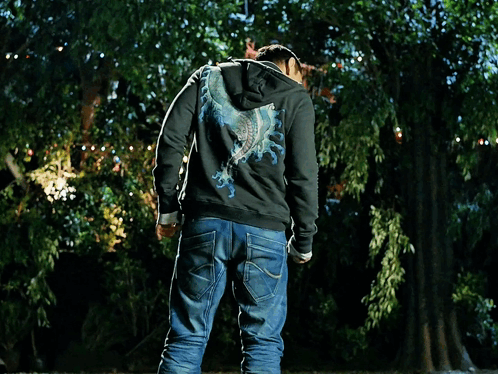 A Man Wearing A Superman T-Shirt And A Black Hoodie GIF