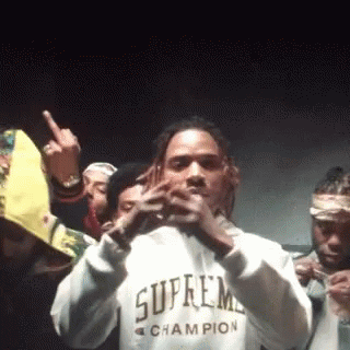 A Man Wearing A Supreme Champion Sweatshirt Is Standing In Front Of A Crowd Of People . GIF