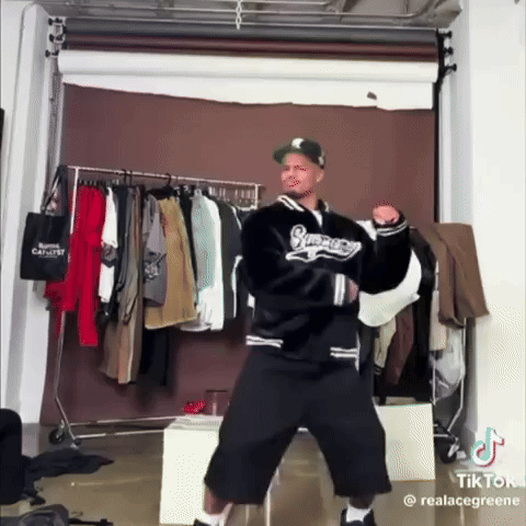 Man In Supreme Jacket Dancing In Front Of Clothes Rack GIF