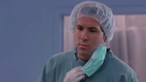 A Man Wearing A Surgical Gown And A Mask Says But Why GIF