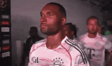 a man wearing a t-mobile jersey stands in a line with other men