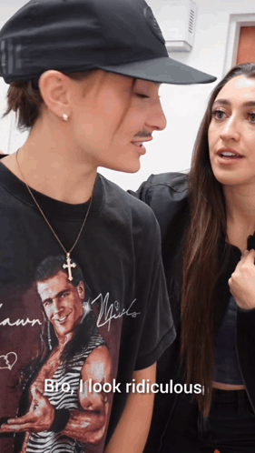 a man wearing a t-shirt that says " bro i look ridiculous " talks to a woman