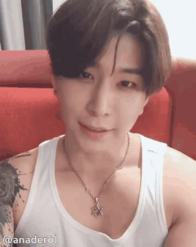A Man Wearing A Tank Top And A Necklace With A Star On It GIF