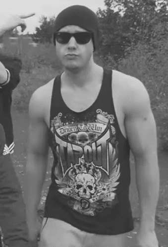 A Man Wearing A Tank Top That Says Driven To Win On It GIF