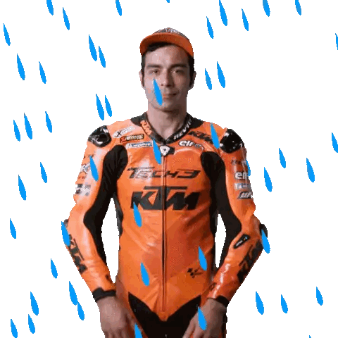 a man wearing a tech3 ktm motorcycle jacket is standing in the rain