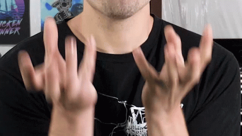 A Man Wearing A Tekken Runner Shirt Holds His Hands Up In The Air GIF