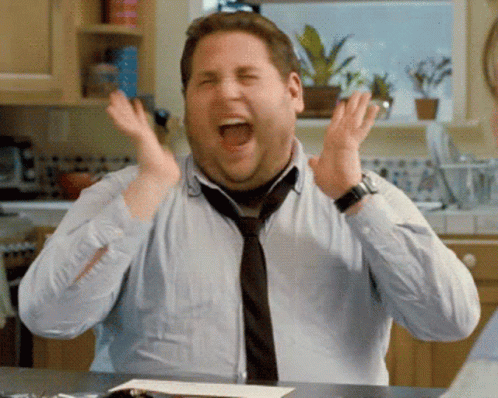 A Man Wearing A Tie And A Watch Is Screaming With His Mouth Open GIF