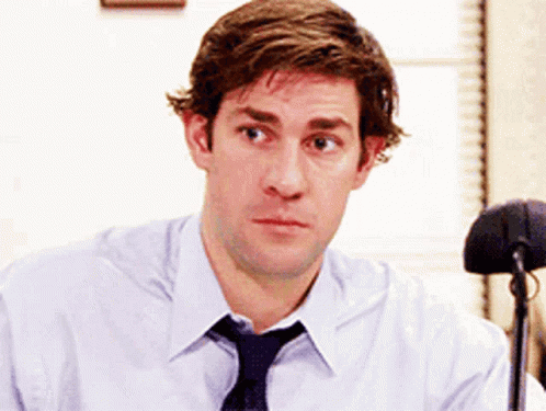 A Man Wearing A Tie And A White Shirt Is Looking At The Camera GIF