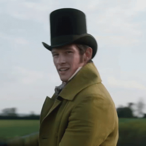 A Man Wearing A Top Hat And A Yellow Coat Is Waving GIF
