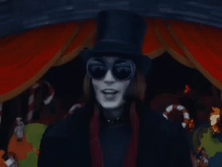 A Man Wearing A Top Hat And Sunglasses Is Standing In Front Of Candy Canes GIF