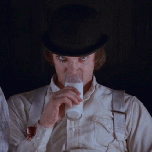 A Man Wearing A Top Hat Is Drinking Milk From A Glass GIF