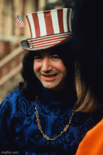 A Man Wearing A Top Hat With A Flag On It GIF