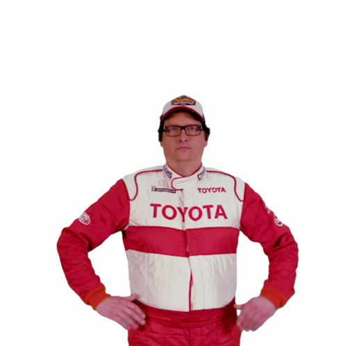 A Man Wearing A Toyota Jacket And A Superman Shirt Holds His Fist Up In The Air GIF