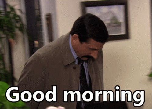 A Man Wearing A Trench Coat And Tie Says Good Morning GIF
