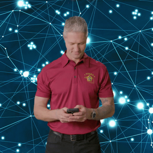 A Man Wearing A Tulsa Shirt Is Looking At His Phone GIF