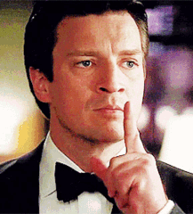 A Man Wearing A Tuxedo And Bow Tie Is Holding His Finger To His Mouth . GIF