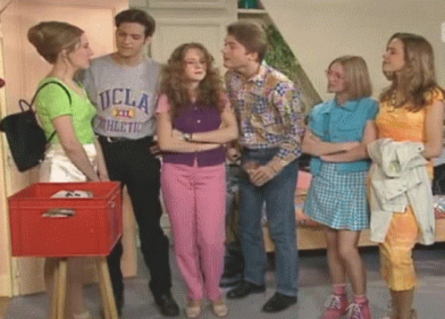 a man wearing a ucla athletic t-shirt talks to three women