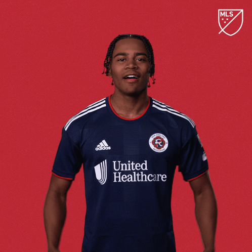 a man wearing a united healthcare jersey stands in front of a red background that says let 's go