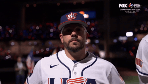 A Man Wearing A Usa Baseball Uniform Stands In Front Of A Fox Broadcast GIF