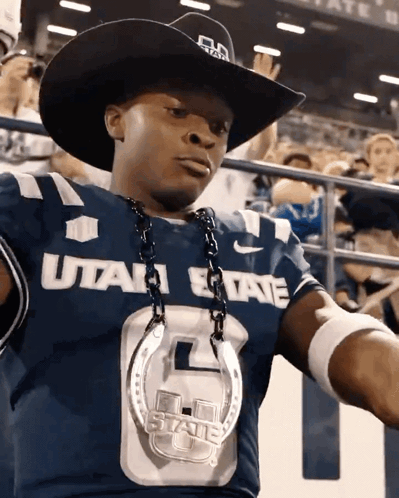 A Man Wearing A Utah State Jersey With A Cowboy Hat GIF