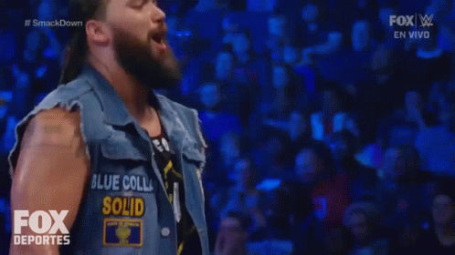 A Man Wearing A Vest That Says Blue Colla Solid On It GIF