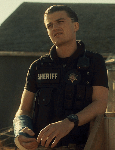 a man wearing a vest that says sheriff on the back