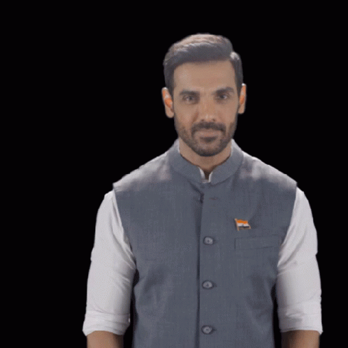 A Man Wearing A Vest With A Flag On It GIF