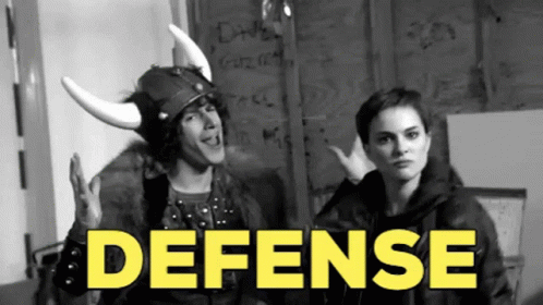 A Man Wearing A Viking Helmet Stands Next To A Woman With The Word Defense In Yellow GIF