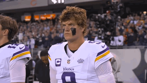 A Man Wearing A Vikings Uniform Stands On The Field GIF