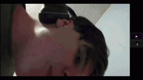a man wearing a virtual reality headset is laying on his back