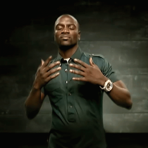 A Man Wearing A Watch Holds His Hands Over His Chest GIF