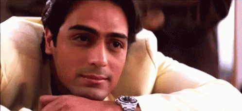 A Man Wearing A Watch Rests His Head On His Hand . GIF