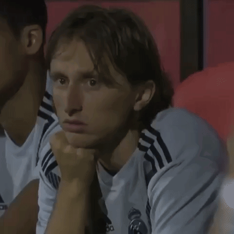 A Man Wearing A White Adidas Shirt Is Sitting In A Stadium GIF