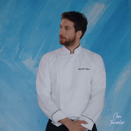 A Man Wearing A White Chef 'S Jacket With The Name Iskender Topuz GIF
