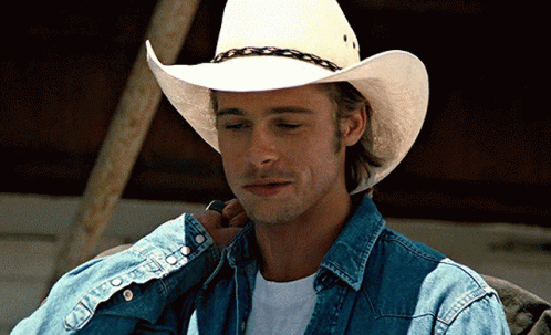 A Man Wearing A White Cowboy Hat And A Denim Shirt GIF