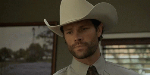 a man wearing a white cowboy hat and tie