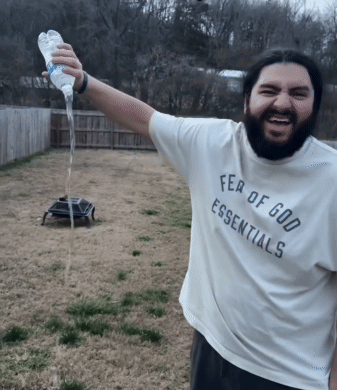 A Man Wearing A White Fear Of God Essentials Shirt GIF