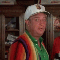 A Man Wearing A White Hat And A Rainbow Sweater Is Standing In Front Of A Locker . GIF