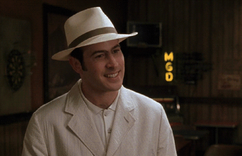 A Man Wearing A White Hat And A White Jacket Stands In Front Of A Sign That Says 360 GIF