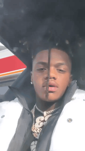A Man Wearing A White Jacket And A Black Shirt With The Number 33 On It GIF