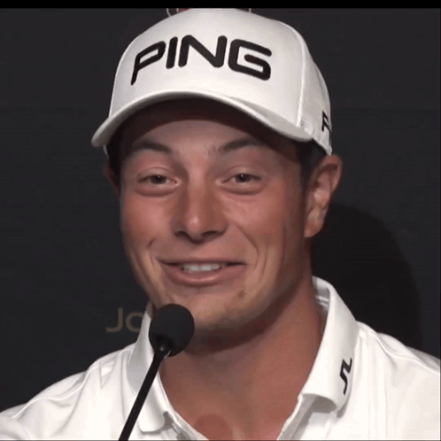 a man wearing a white ping hat is smiling